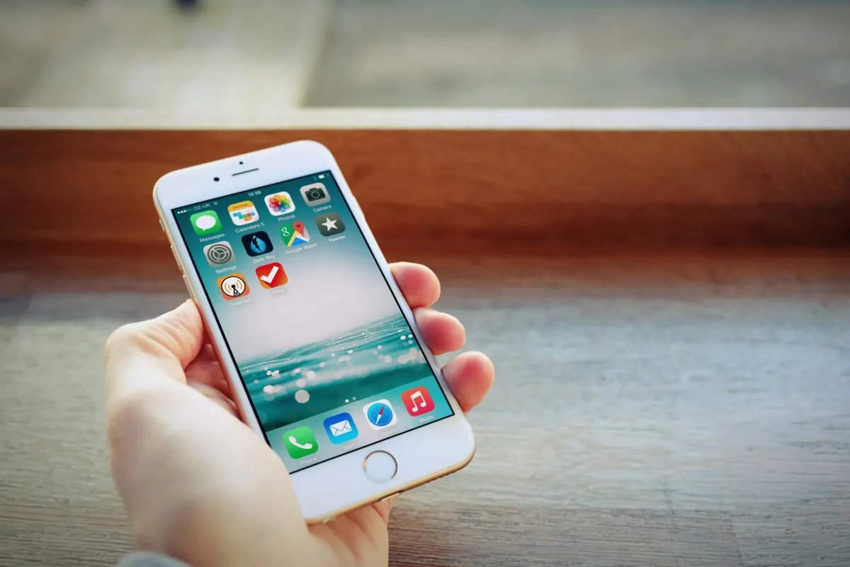 Close-up of an iPhone with app icons in hand