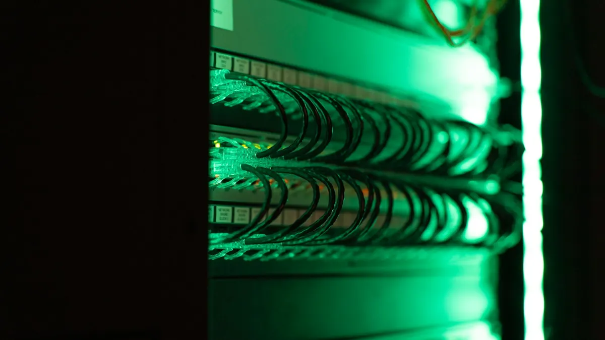 Network cables lit by a green glow inside a server rack