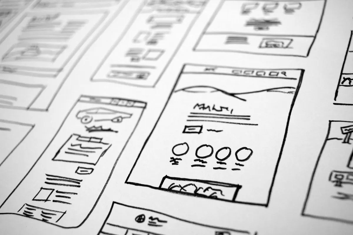 Hand-drawn app wireframes on paper